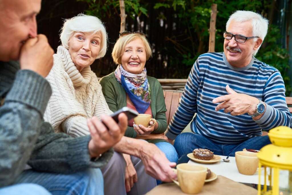 group of seniors having coffee outside at senior living community