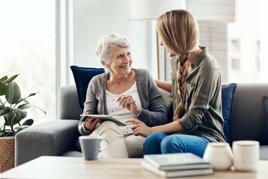 older adult and adult child looking at a tablet