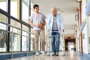 assisted living vs nursing home a nurse with an older adult using a walker