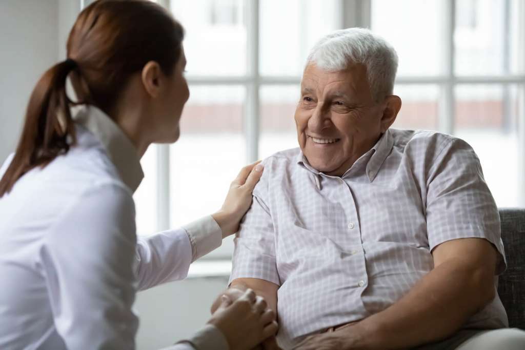 care giver with older adult talking about does medicare cover assisted living