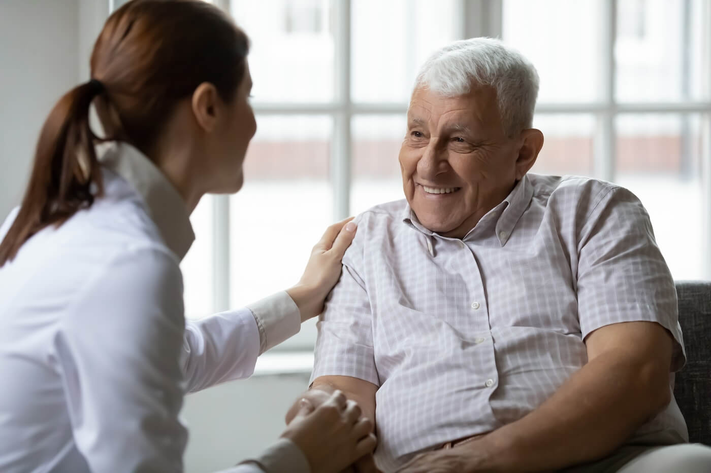 care giver with older adult talking about does medicare cover assisted living