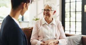 senior with caregiver smiling after a senior living tour questions to ask