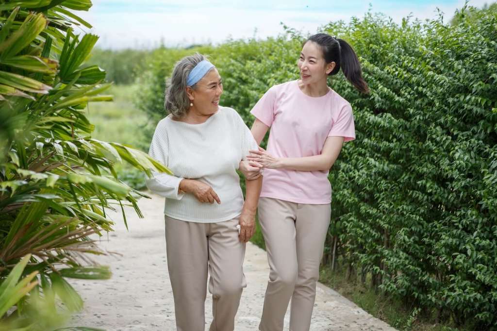 adult daughter walking with senior mom outside and talking because she is lonely