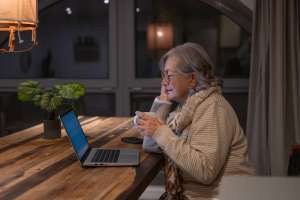 senior women sitting at kitchen table in the evening during daylight saving time and elderly parent